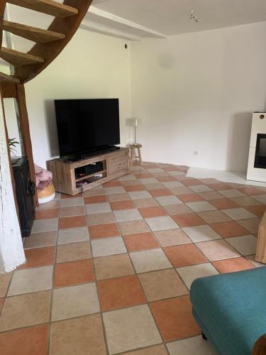 a living room with a tiled floor and a flat screen tv at Saint Martin in Roézé-sur-Sarthe