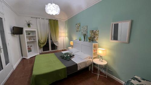 um quarto com uma cama com um cobertor verde em B&B Doralice em Catânia
