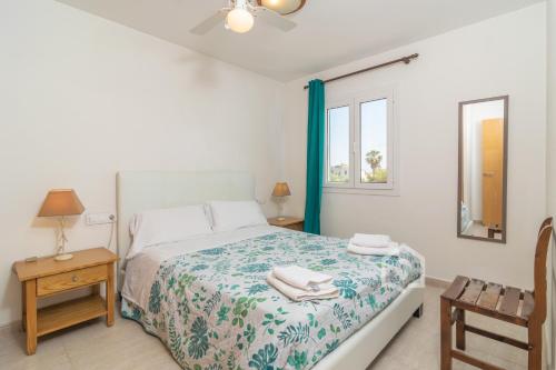 a bedroom with a bed and a table and a chair at Apartamento SARAY in Son Carrio
