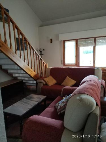 a living room with a couch and a staircase at La lechuza blanca in Casavieja
