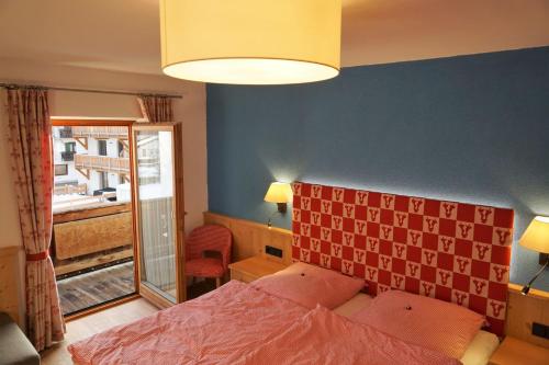 a bedroom with a bed with a red headboard and a window at Haus Zauner in Reit im Winkl