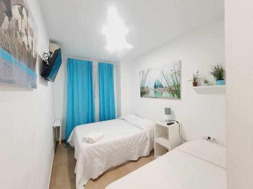 a white room with two beds and a window at Vivienda Turistica Valencia A1 Grandes Grupos in Valencia