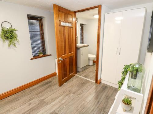 a hallway with a wooden door and a toilet at Dale Cottage in Oldham