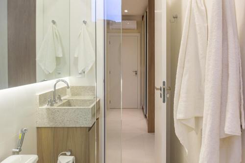 y baño con lavabo, aseo y espejo. en Apartamento com Terraço a 300m da Praia em Itapema P1771, en Itapema