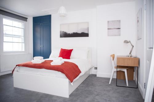 um quarto com uma cama com um cobertor vermelho e uma secretária em Special Offer! Lovely studio - ZONE 1 - Hyde Park em Londres