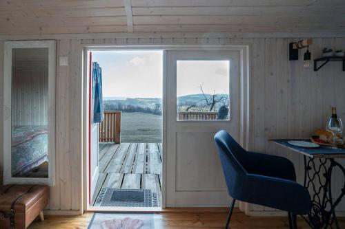 Zimmer mit einer Tür, die auf eine Terrasse mit einem Stuhl führt in der Unterkunft Naphegy Kuckó in Écs