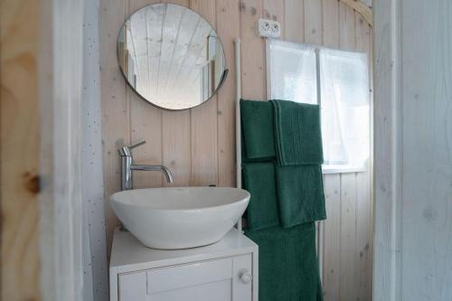 y baño con lavabo, espejo y toallas verdes. en Naphegy Kuckó, en Écs