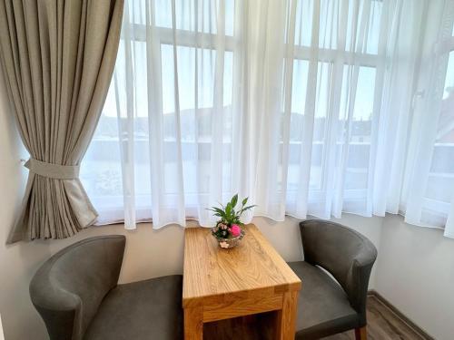 a table and two chairs in front of a window at SYNEK Pension in Špindlerův Mlýn