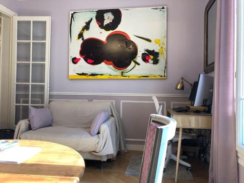 a living room with a couch and a painting on the wall at Gobelins in Paris