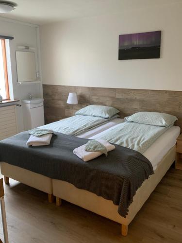 1 dormitorio con 1 cama grande y 2 toallas. en Skammidalur Guesthouse, en Vík