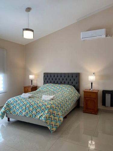 een slaapkamer met een bed en twee nachtkastjes bij Chalet al pie del camino al cuadrado in Río Ceballos