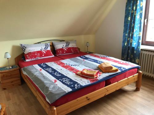 ビューズムにあるLolo's Ferienwohnungのベッド(赤と白の枕付)