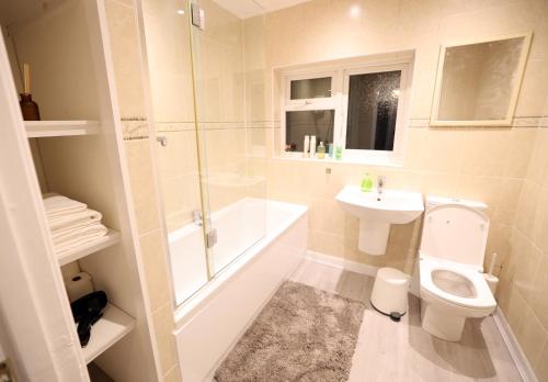 a bathroom with a toilet and a sink and a shower at Bath City Skyline Spacious 3 Bed House for family in Bath