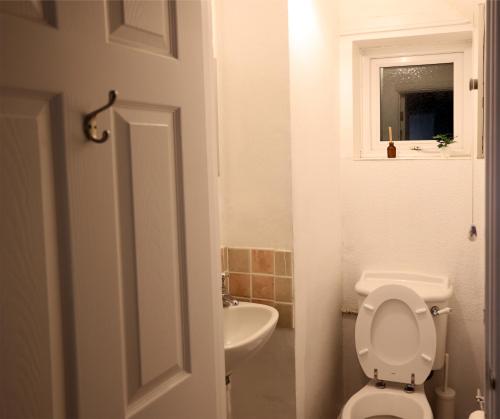a white bathroom with a toilet and a sink at Bath City Skyline Spacious 3 Bed House for family in Bath