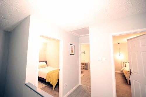 a view of a bedroom with a bed and a mirror at Bath City Skyline Spacious 3 Bed House for family in Bath