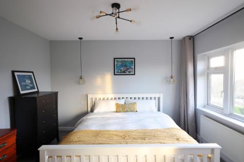 a bedroom with a white bed and a window at Bath City Skyline Spacious 3 Bed House for family in Bath