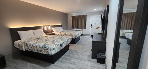 una camera d'albergo con due letti e una televisione di Motel 6 Aransas Pass TX ad Aransas Pass