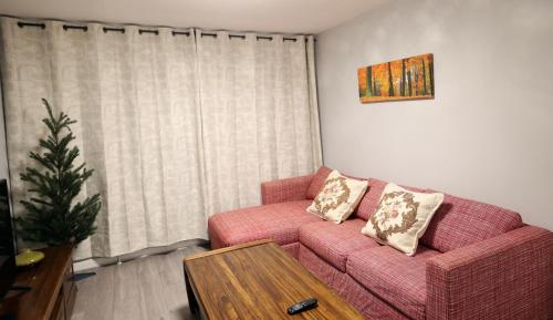 a living room with a pink couch and a table at Bath City Skyline Spacious 3 Bed House for family in Bath