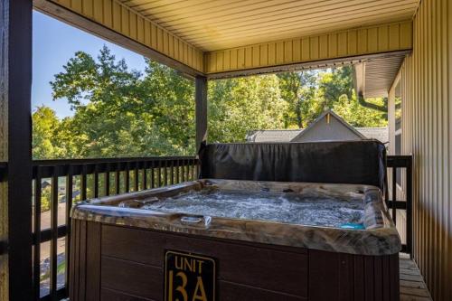 bañera de hidromasaje en una terraza con ventana grande en Briarstone Lodge Condo 13A, en Pigeon Forge