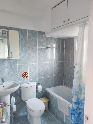 a bathroom with a toilet and a sink and a tub at Hawaii Royal Gardens 2 in Limassol