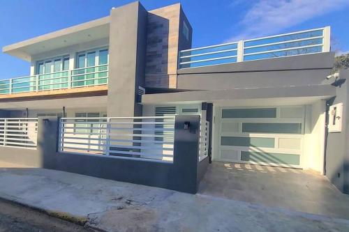 una casa grande con una entrada delante de ella en Cheerful 8-bedroom Villa with Pool & Patio, en San Juan