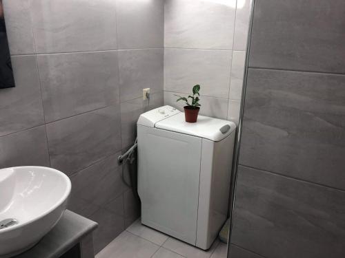 a bathroom with a sink and a small refrigerator at Bright apartment in Nea Palatia • Oropos in Néa Palátia