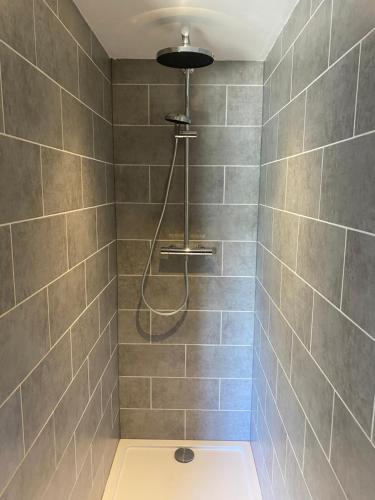 uma casa de banho com chuveiro e cabeça de chuveiro em De Bloesem em Cothen