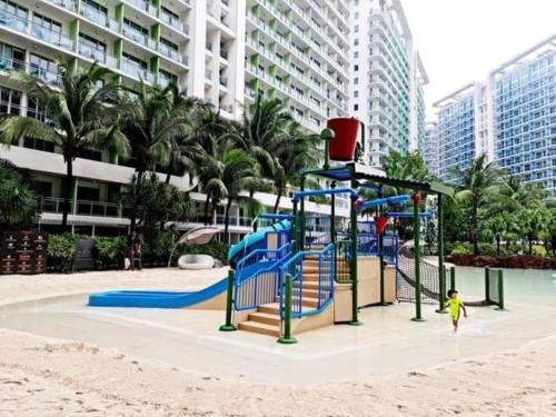 einen Spielplatz am Strand in der Nähe eines Gebäudes in der Unterkunft Azure BEACHfront view Aesthetic Minimalist unit in Manila