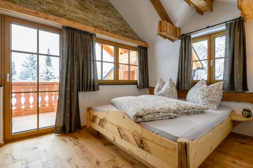 a bedroom with a wooden bed and windows at Goiserer Chalet in Bad Goisern