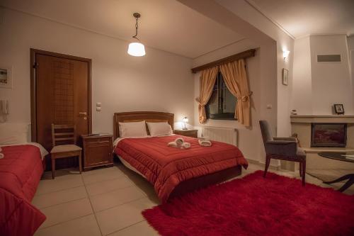 a bedroom with a red bed and a table and chair at Nefeles in Neochori