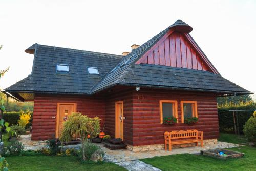 una pequeña casa de madera con un banco delante en River Cottage Bešeňová, en Bešeňová