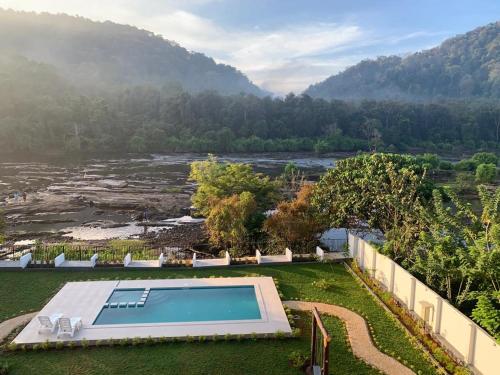 a swimming pool in a yard next to a river at Seeheim Resorts in Athirappilly