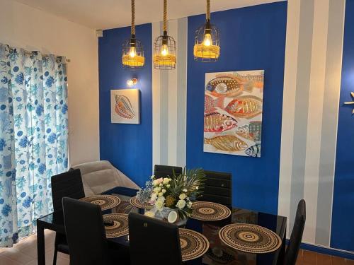 ein Esszimmer mit einem Tisch und einer blauen Wand in der Unterkunft Montaguvilla#3 in Flic-en-Flac