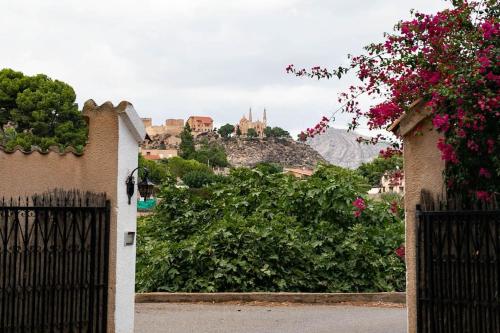 a gate to a house with a castle in the background at Villa Molinos in Novelda