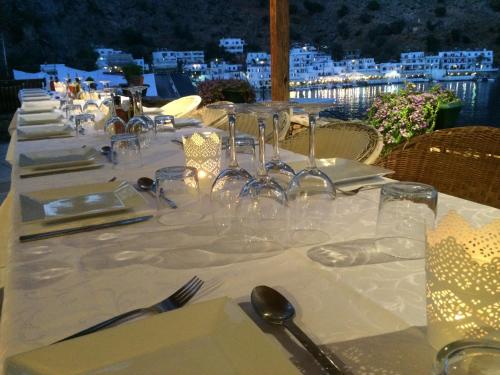 a long table with wine glasses and silverware on it at Hotel Porto Loutro on the Hill in Loutro
