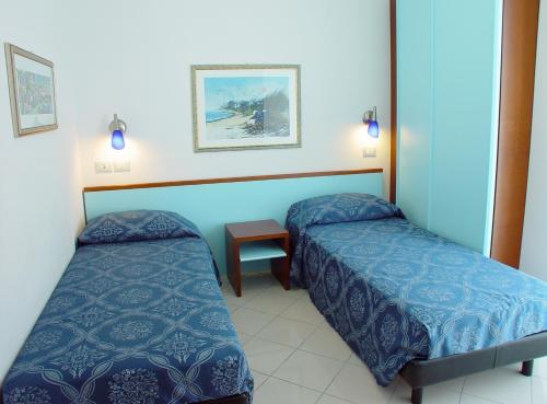 a hotel room with two beds and a table at Residence Oltremare in San Benedetto del Tronto