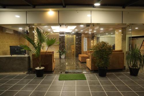 a lobby with potted plants in a building at DREAMS PARADISE AIRPORT RESIDENCY in Nedumbassery
