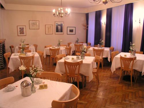 a dining room with tables and chairs with white linens at Kindl 's Low Budget in Vienna