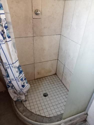 um chuveiro com um ralo no chão e uma cortina de chuveiro em Lamont Lodge em Durban