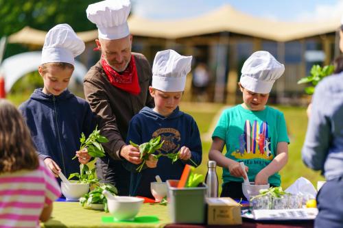 a man and children in chefs hats preparing food at Woolley Grange Hotel in Bradford on Avon