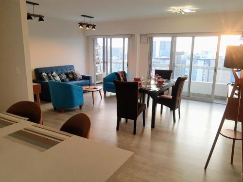 Encantador apartamento en Miraflores في ليما: غرفة معيشة مع طاولة وكراسي وأريكة