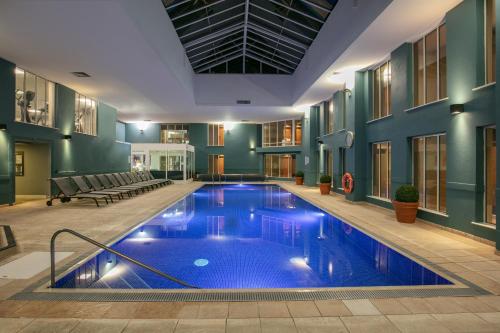 een groot zwembad in een gebouw met een zwembad bij Norton Park Hotel, Spa & Manor House - Winchester in Sutton Scotney