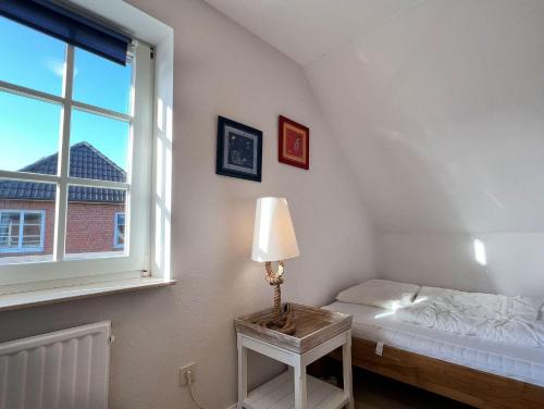 a bedroom with a bed and a window at Haus-Halli-Een-Whg-07 in Sankt Peter-Ording