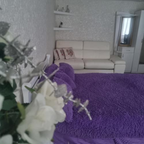 sala de estar con alfombra morada y sofá blanco en White apartament, en Kremenchuk