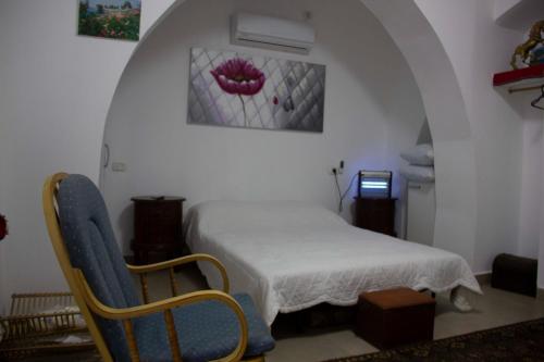 a bedroom with a bed and two chairs in a room at Shamokh House in Acre