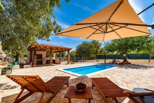 patio con piscina e ombrellone di MY DALMATIA - Authentic villa Malou with private swimming pool a Stankovci