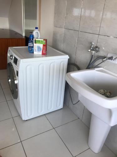 a washing machine in a bathroom next to a sink at Sobrado in Curitiba