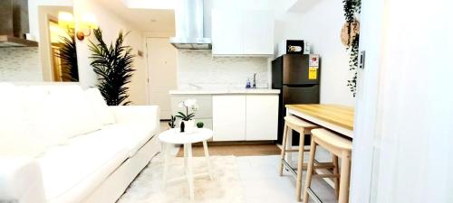 a small kitchen with white cabinets and a table at Azure BEACHfront view Aesthetic Minimalist unit in Manila