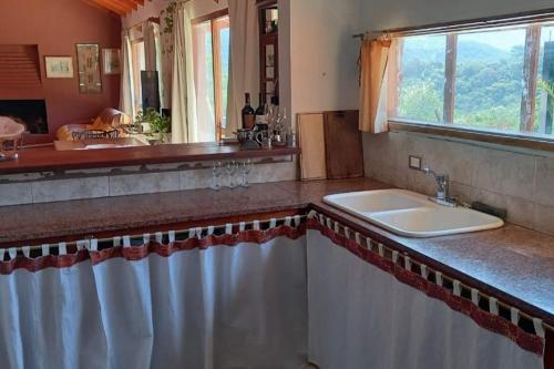baño con lavabo y ventana en Los Forasteros en Córdoba