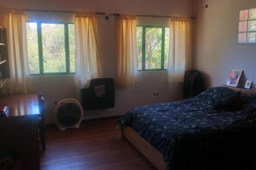 1 dormitorio con 1 cama y 2 ventanas en Los Forasteros en Córdoba